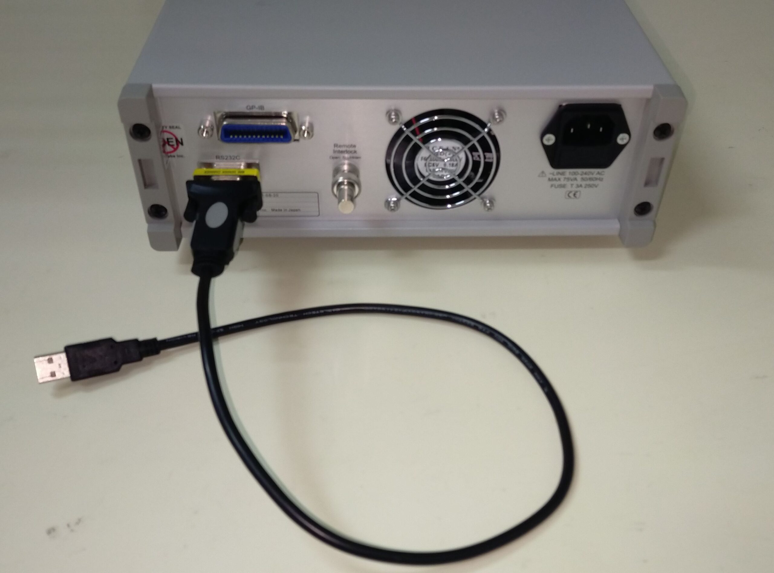USB-serial cable and DB9 gender changer attached onto FiberLabs' bench-top chassis